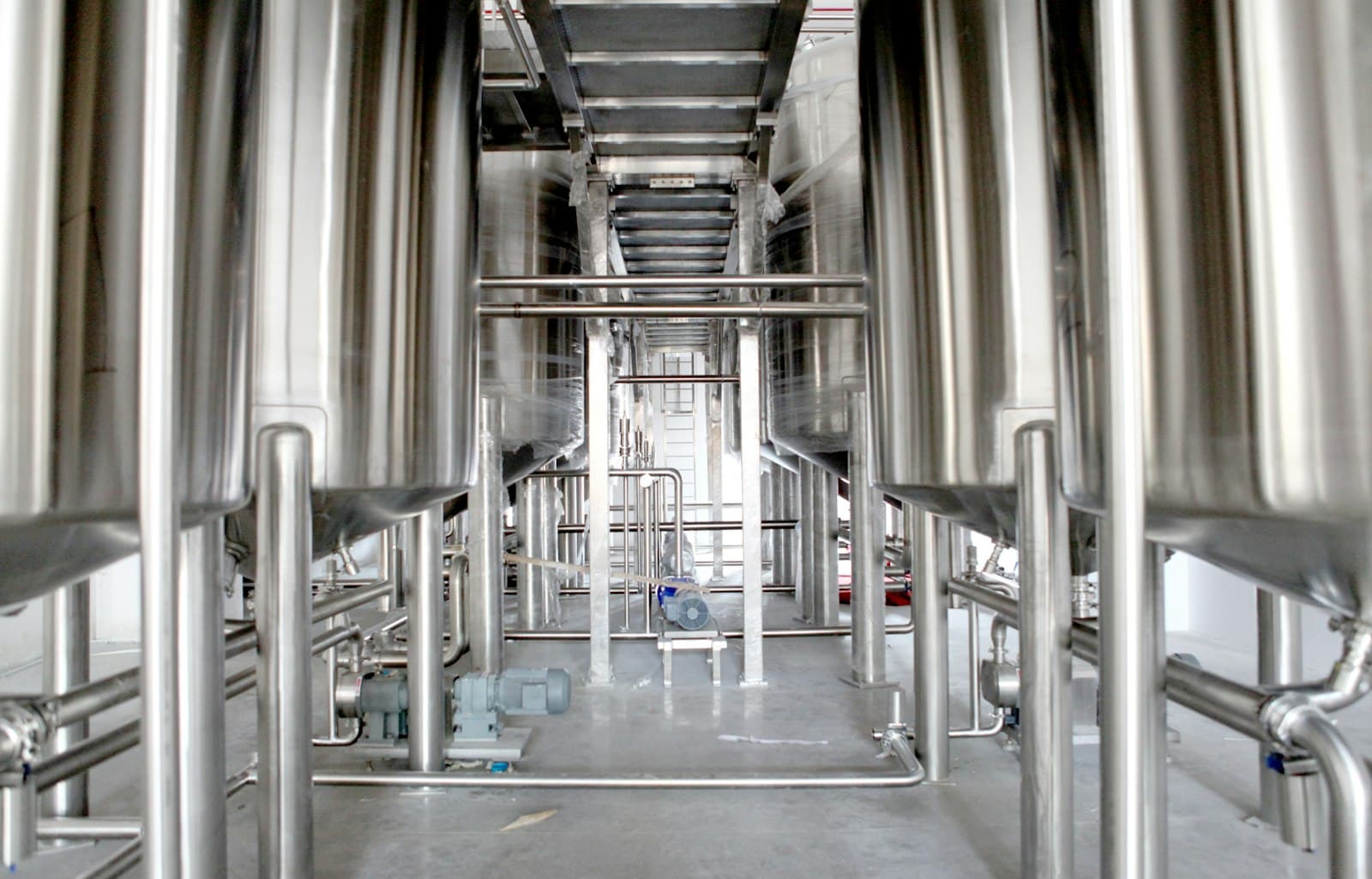 Stainless-steel industrial filtration equipment and pipework in a production facility.